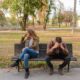 Two people sitting on a bench, arguing.