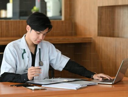 Smart doctor in white uniform working in medical clinic.